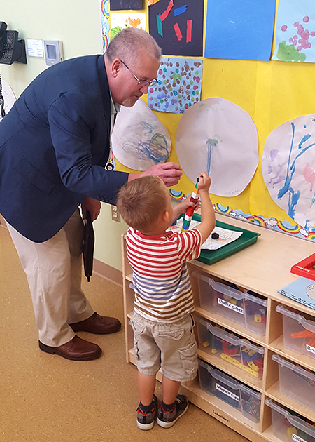 Assistant Superintendent of Teaching and Learning, Mike Nerland, visiting with a preschooler at Hough Early Learning Center.