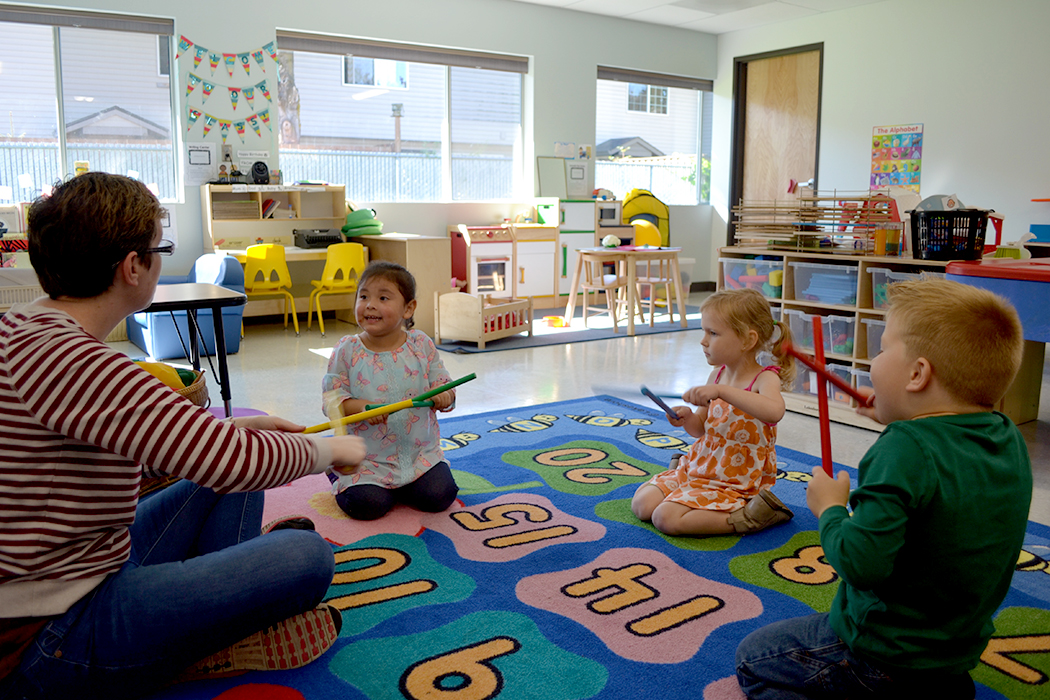Heather Anderson and a group of preschoolers keep the beat during an afternoon preschool session.