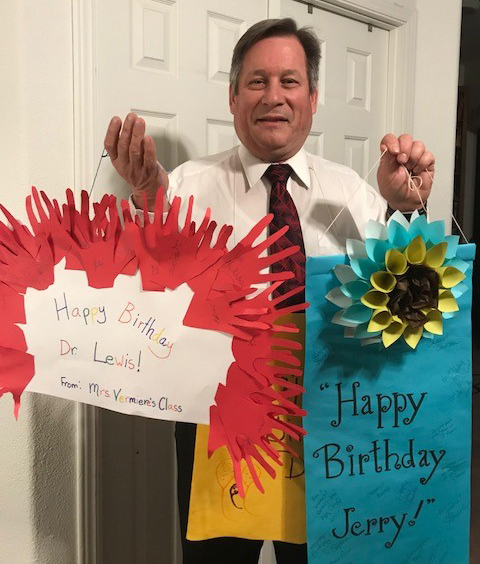 Superintendent Lewis holding his birthday banners