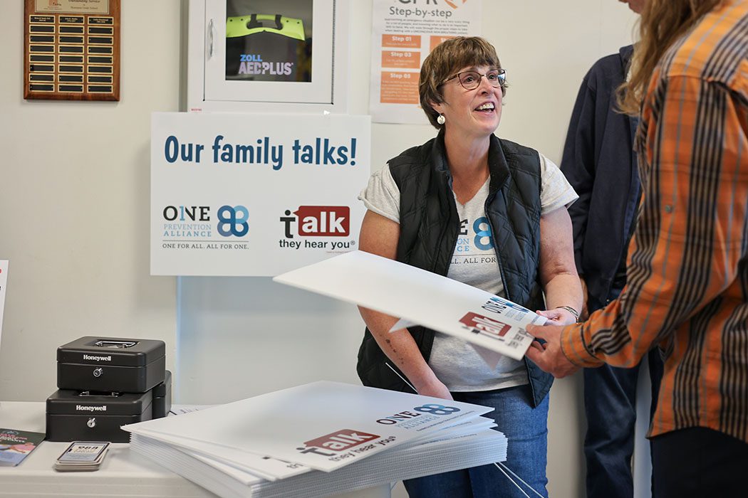 Karen Douglass hands out blank yard signs to families