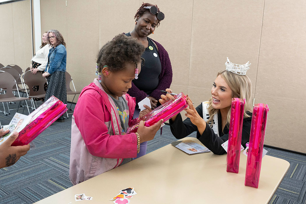 A girl and her family receive a Barbie doll from Miss Washington
