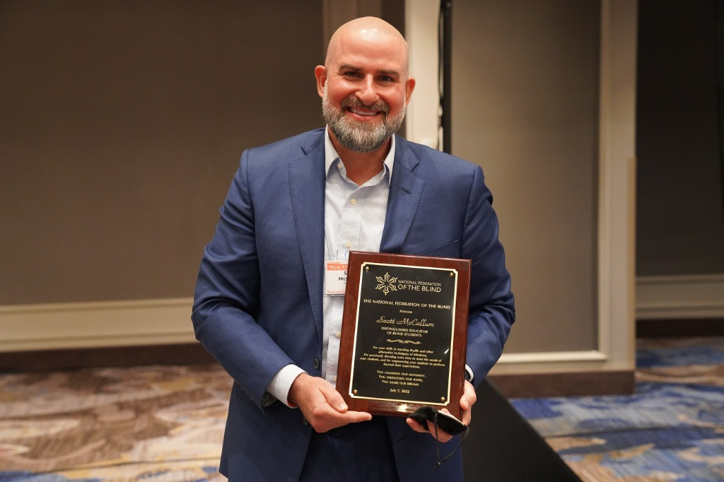 Scott McCallum, Superintendent of the Washington State School for the Blind, holding the award for 2022 Distinguished Educator of Blind Students at the National Federation of the Blind Convention in July 2022